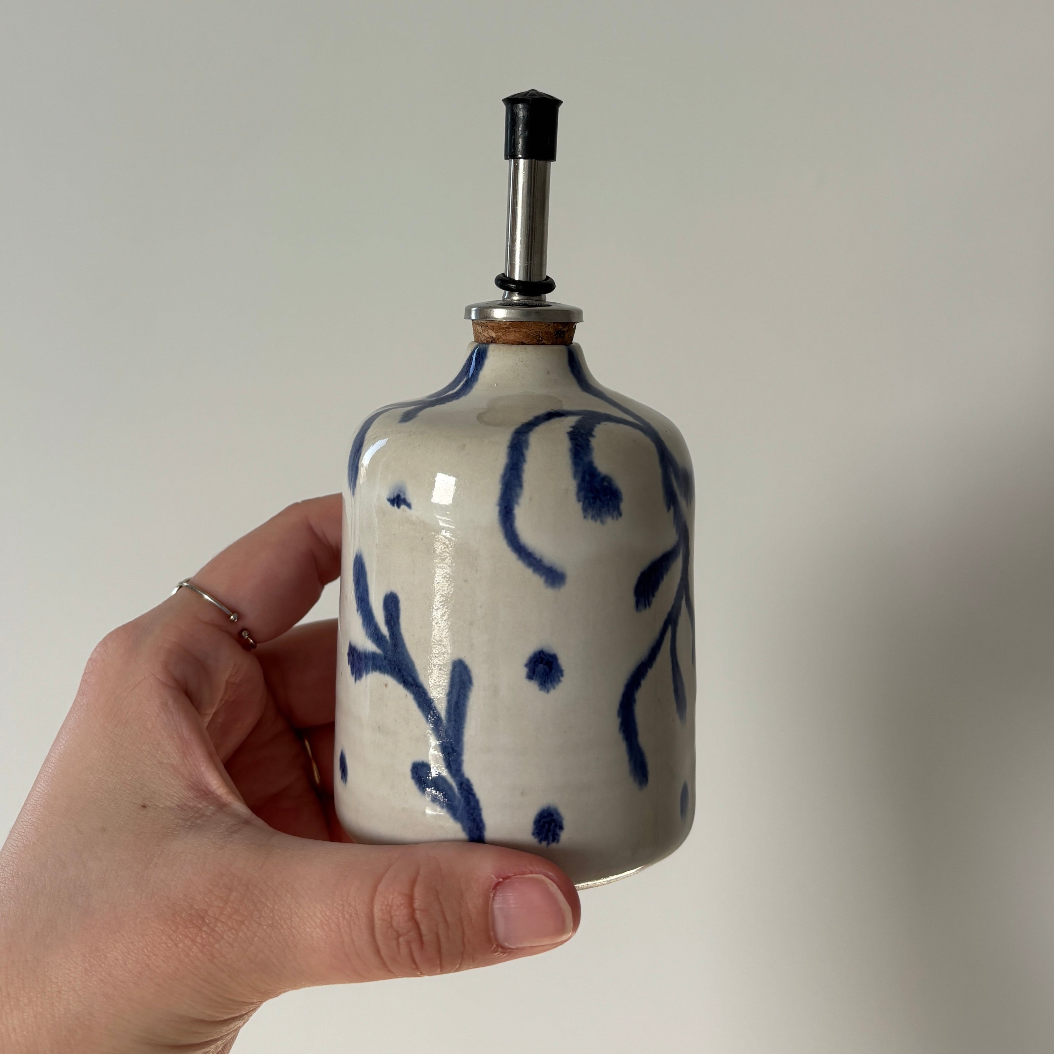 Photo d'un contenant à huile blanc avec des motifs bleus