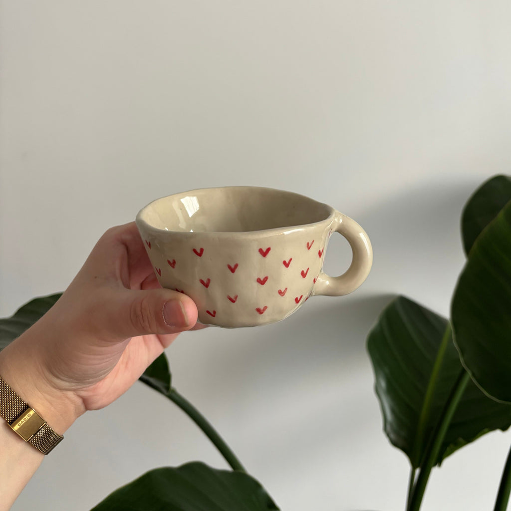 Tasse en céramique avec des cœurs rouges